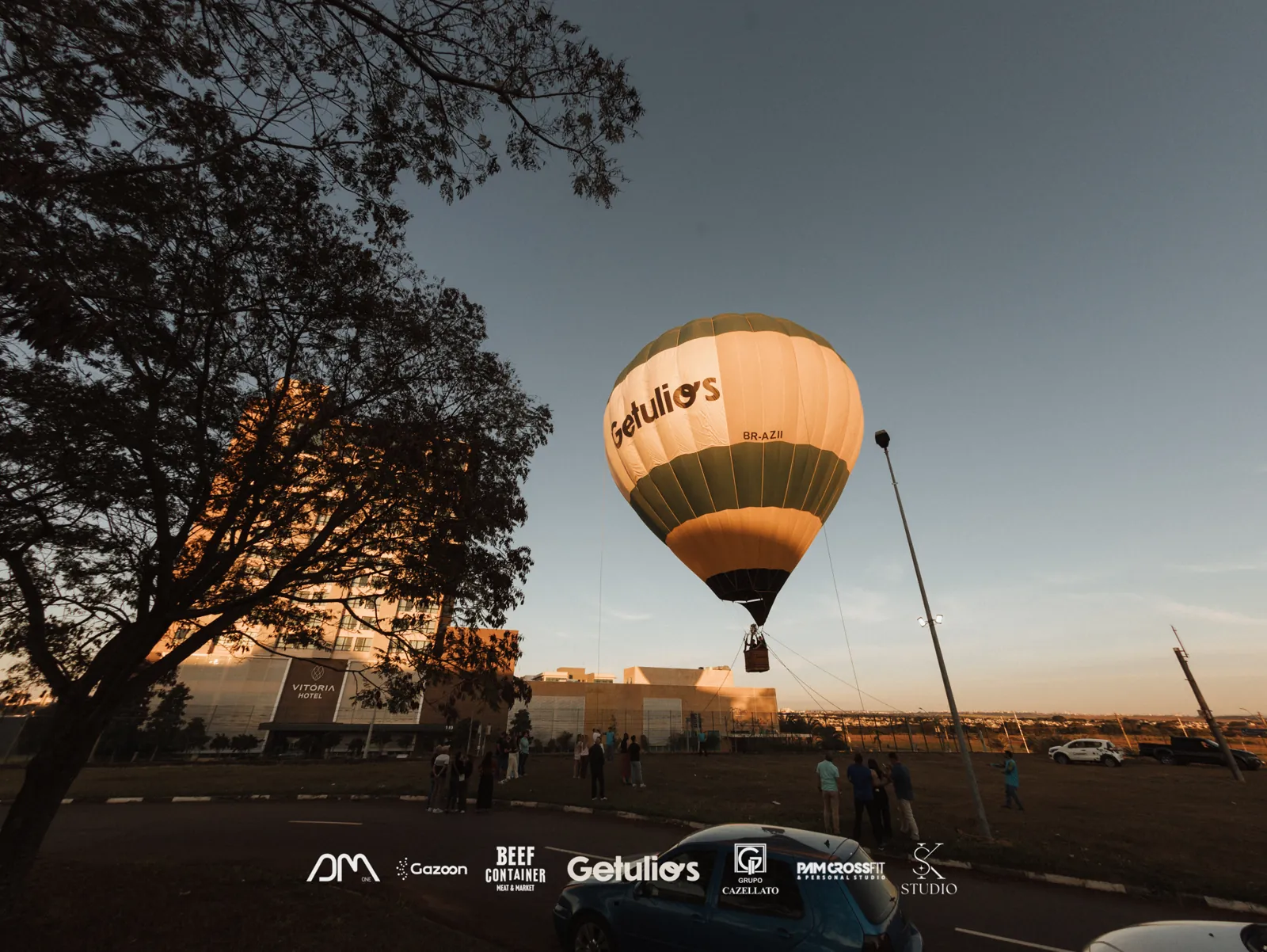 Balão de ar quente com a marca do patrocinador ao pôr do sol, foto com as logos estampadas